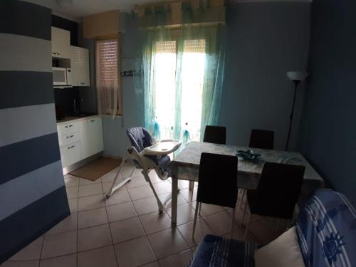 una cucina con tavolo e sedie in una stanza di A due passi dal mare a Marina di Carrara