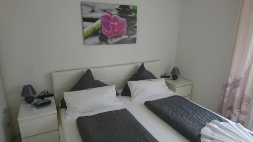 ein Schlafzimmer mit 2 Betten und einem Bild an der Wand in der Unterkunft Apartment City in Radolfzell am Bodensee