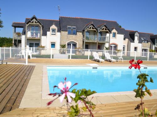 a swimming pool in front of a house at Apparthôtel Mont Saint Michel - Résidence Fleurdumont in Beauvoir