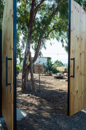 a wooden door leading to a tree with a sign at NATURA-eco farm in Natur