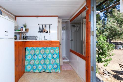 una cocina con una puerta abierta con una colcha colorida en NATURA-eco farm, en Natur