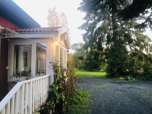 a porch of a house with a white fence at Lilla lägenheten Västra Karstorp in Aneby