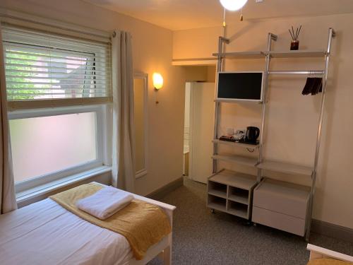a bedroom with a bed and a book shelf at Waterfront Inn in Shanklin