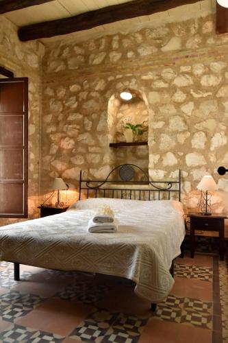 una camera con un letto in una parete in pietra di Casas Rurales Las Viñas a Osuna