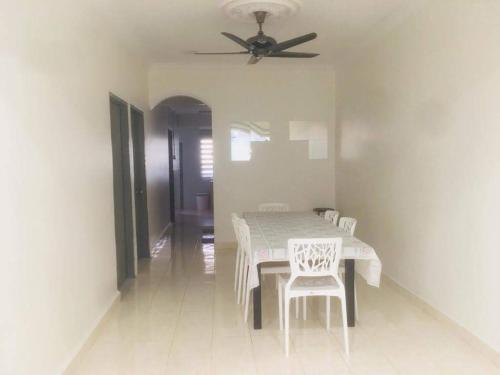 a dining room with a table and chairs and a ceiling fan at Home2Stay Damia @ Bukit Katil in Malacca