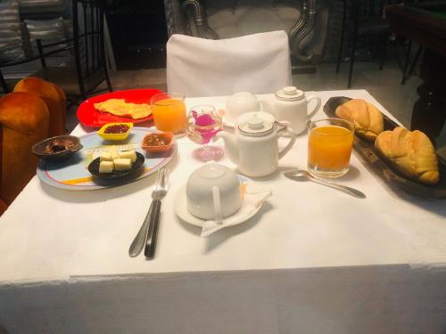 a table with breakfast foods and glasses of orange juice at Petite Flower Guest House in Talata-maty
