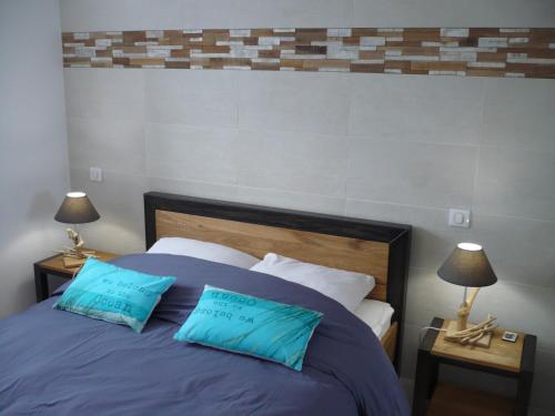 une chambre avec un lit avec deux oreillers bleus dans l'établissement Appartement Cap Sud Vue Mer à 30m de la Plage, à Wimereux