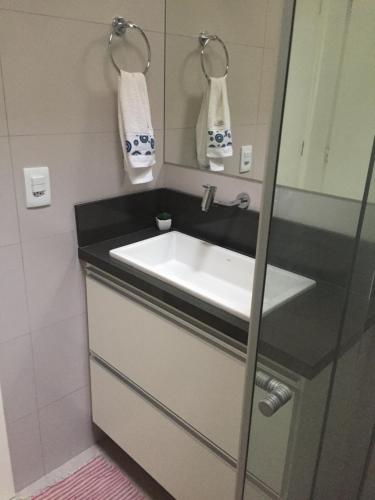 um banheiro com uma pia e um espelho em Charmoso e Confortável em Brasília