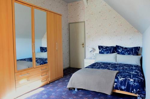 ein Schlafzimmer mit einem Bett und einem großen Spiegel in der Unterkunft Ferienwohnung Wilhelm in Springstille