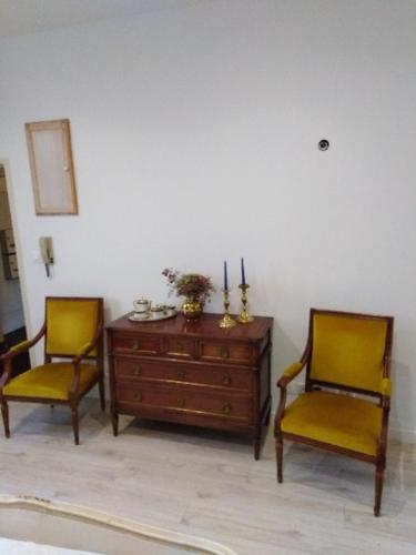 2 sillas y un tocador de madera en una habitación en Maponi, en Dijon