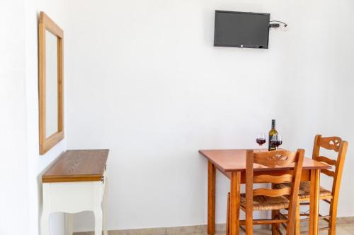 a dining room table and chairs with a tv on the wall at Studio Tolakis in Plaka
