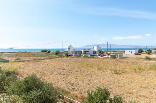 a field with houses and the ocean in the background at Studio Tolakis in Plaka