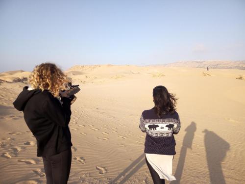 two women standing on the sand in the desert at GOLVEN Surf in Taghazout