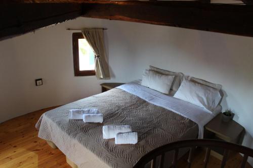 a bedroom with a bed with two towels on it at Kefalonian Mill - Oneira Villas in Trapezaki