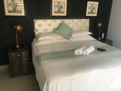 1 cama blanca grande con 2 toallas en 2 on ZK Matthews Guesthouse en Mthatha