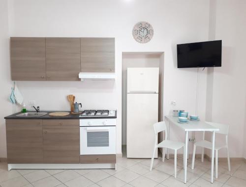 een keuken met een witte koelkast en een tafel bij Casa Mia Miniapartment in Riposto
