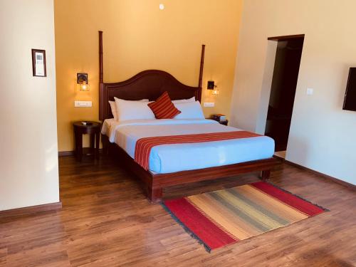 a bedroom with a large bed with a wooden headboard at Machaan Plantation Resort, Sakleshpur in Sakleshpur