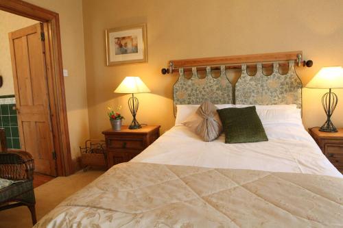 a bedroom with a large white bed with two pillows at Badgers Inn in Petworth