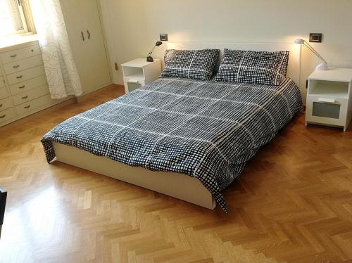 a bedroom with a bed with a plaid comforter and two night stands at Bologna Center Town in Bologna