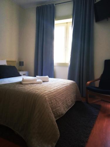 1 dormitorio con 1 cama con cortinas azules y ventana en Villa Regio Garden en Vila do Conde