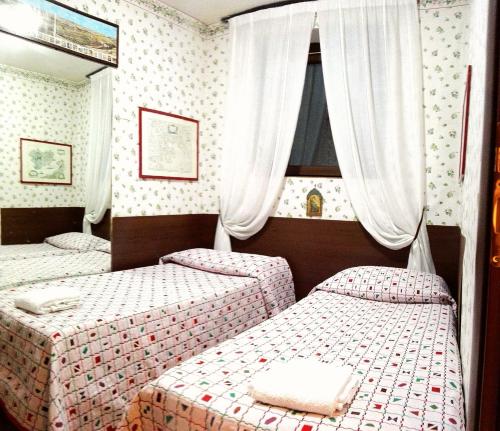 1 dormitorio con 2 camas y espejo en Il Vascello, en Castel San Pietro Romano