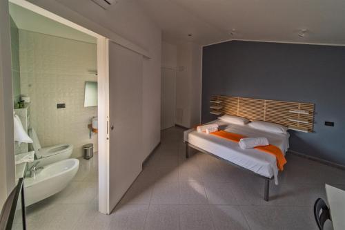 a bathroom with two beds and a tub and a sink at Chiara’s Home in Davoli