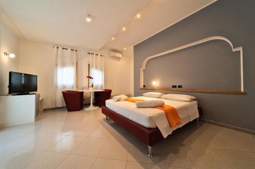 a bedroom with a bed and a flat screen tv at Chiara’s Home in Davoli
