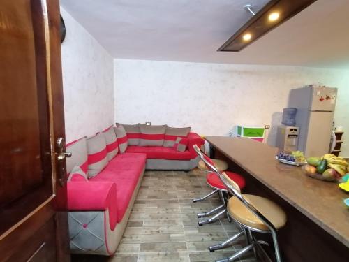 a living room with a red couch and a table at Mhna guest house in Ajloun