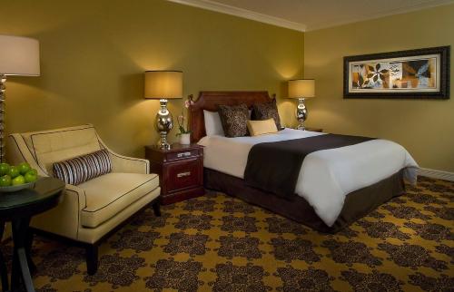 a bedroom with a large bed and a chair at Omni Houston Hotel in Houston