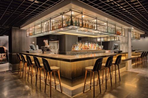 a bar with a bunch of stools in a room at Omni Houston Hotel in Houston