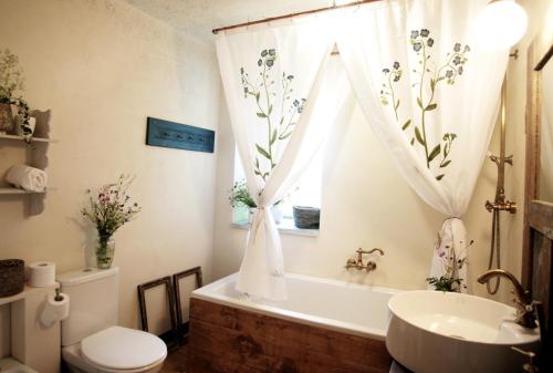 a bathroom with a tub and a toilet and a sink at U Květů in Milešov