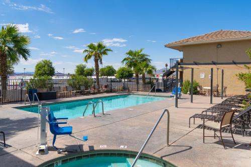 a swimming pool at a resort with chairs at Days Inn by Wyndham Lake Havasu in Lake Havasu City
