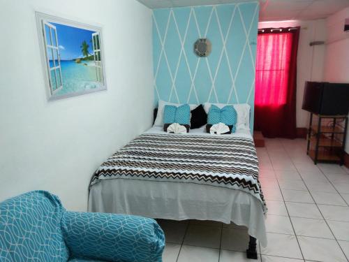 1 dormitorio con cama y sofá en The Red Hut Inn en Ciudad de Belice
