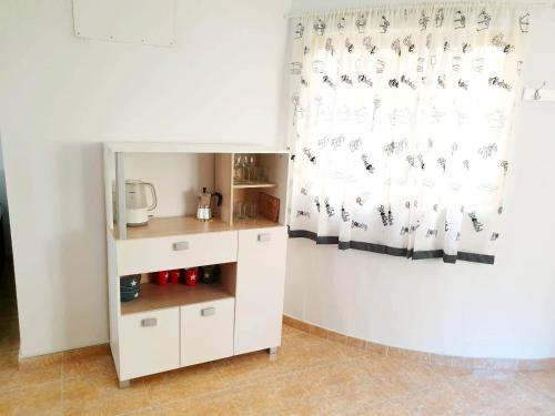 a small kitchen with white cabinets and a curtain at RUZAFA 17, OLD TOWN in Benidorm