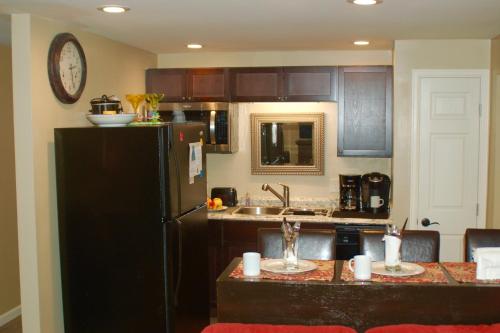 Una cocina con un refrigerador negro y un fregadero. en Blue Bear Den 3BR 2BA DTC Private Apt Hot Tub, en Denver