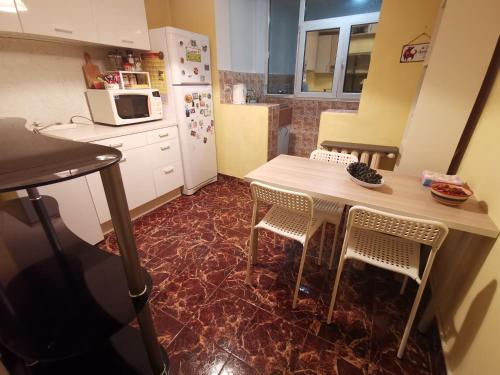 una cucina con tavolo, sedie e frigorifero di Spacious quiet apartment next to Arena Armeec and Metro station GM Dimitrov a Sofia