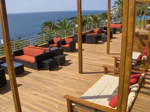a row of lounge chairs sitting on top of a wooden deck at Pestana Promenade Ocean Resort Hotel in Funchal