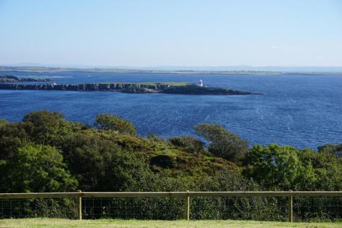 an island in the water with a lighthouse on it at Lighthouse Cottage in Donegal