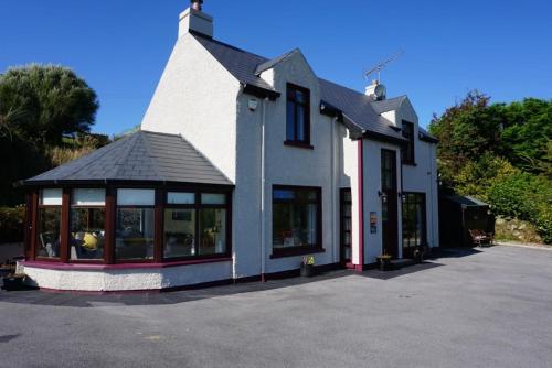 a white building with a lot of windows at Lighthouse Cottage in Donegal