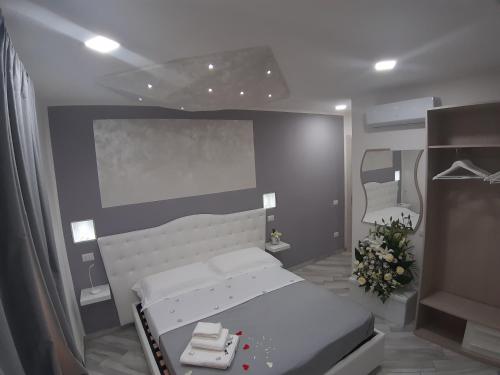 a bedroom with a white bed and a gray wall at Il Diamante in Crotone