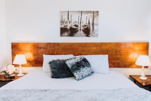 a bedroom with a white bed with two lamps at Tamworth City Motel in Tamworth