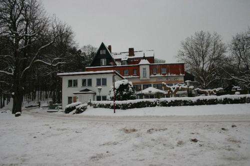 ein großes Haus ist mit Schnee bedeckt in einem Hof in der Unterkunft Ambiente Hotel Papenhof in Elze