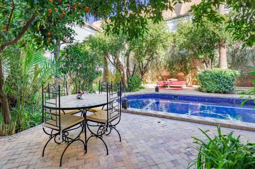 a patio with a table and chairs next to a pool at Riad Laila in Marrakech