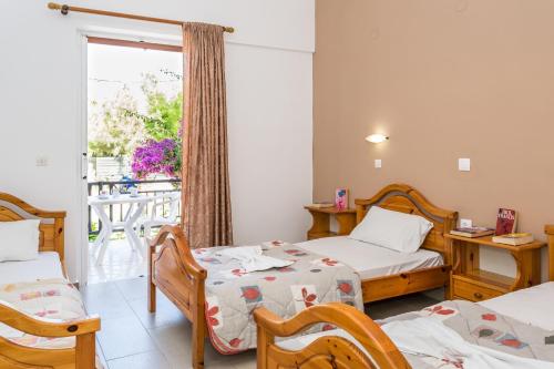 a room with two beds and a balcony at COSTAS HOTEL in Zakynthos