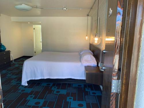 a bedroom with a white bed in a room at The Sands Motel in Boulder City