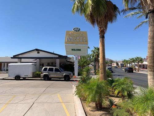 a sign in front of a motel with a car dealership at The Sands Motel in Boulder City