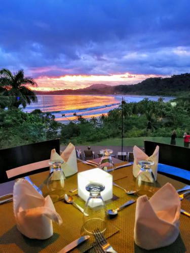 a dining table with a view of the ocean at Nammbú Beach Front Bungalows in Sámara