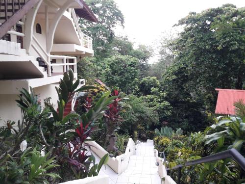 a stairway leading up to a building with trees at Hotel La Colina in Manuel Antonio