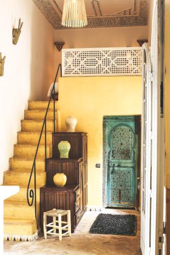 a staircase with a blue door in a house at Riad Laila in Marrakech