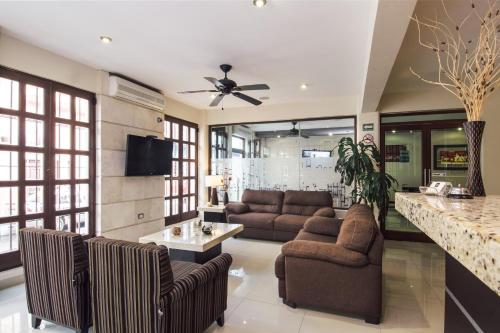a living room with two couches and a kitchen at Hotel Majova Inn Xalapa in Xalapa